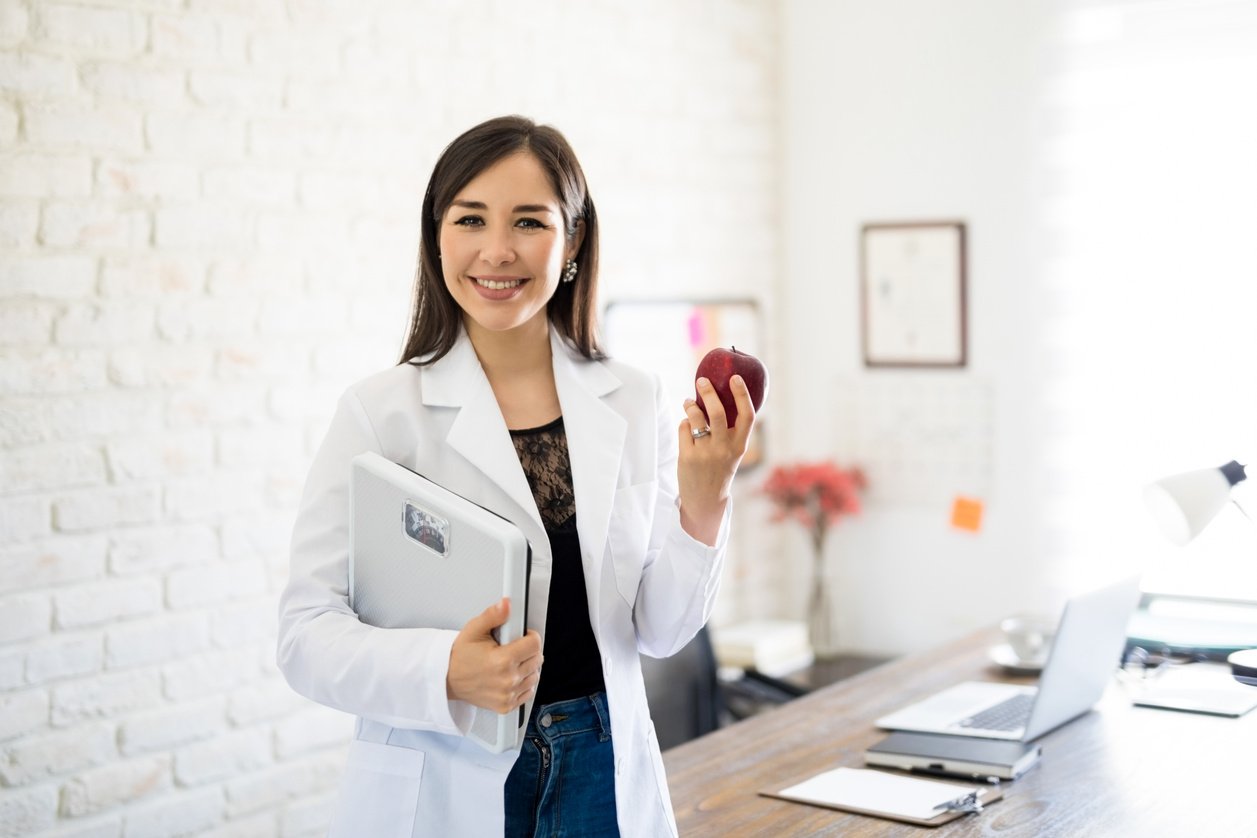 Dietitian with weight scale and apple