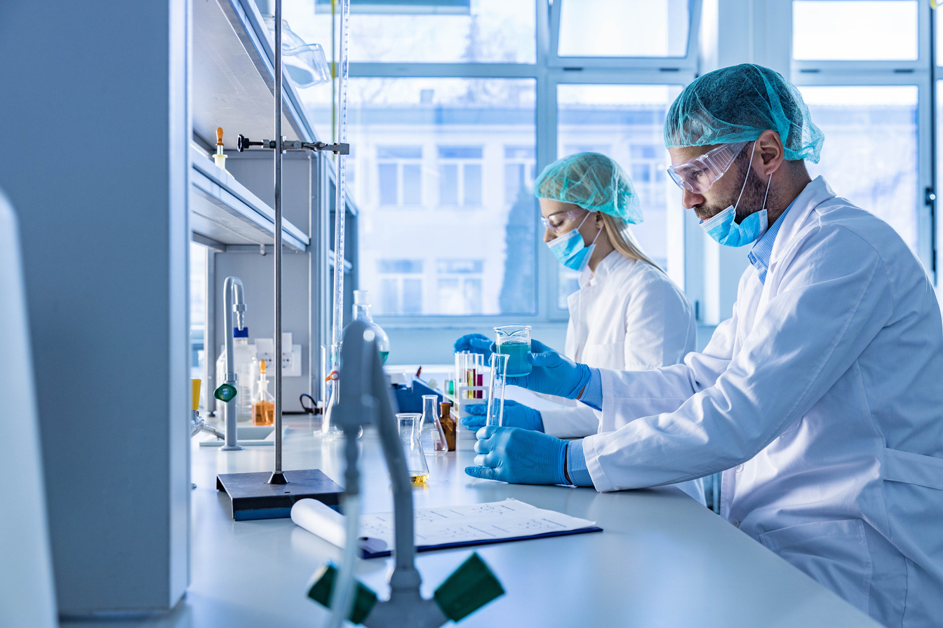 Two scientists working on a medical experiment in laboratory.